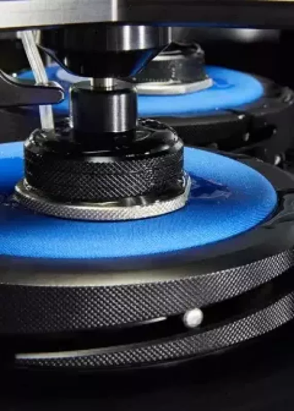 Zbliżenie stanowisk testowych AquAbrasion z&nbsp;niebieskimi podkładkami do badania ścieralności na mokro