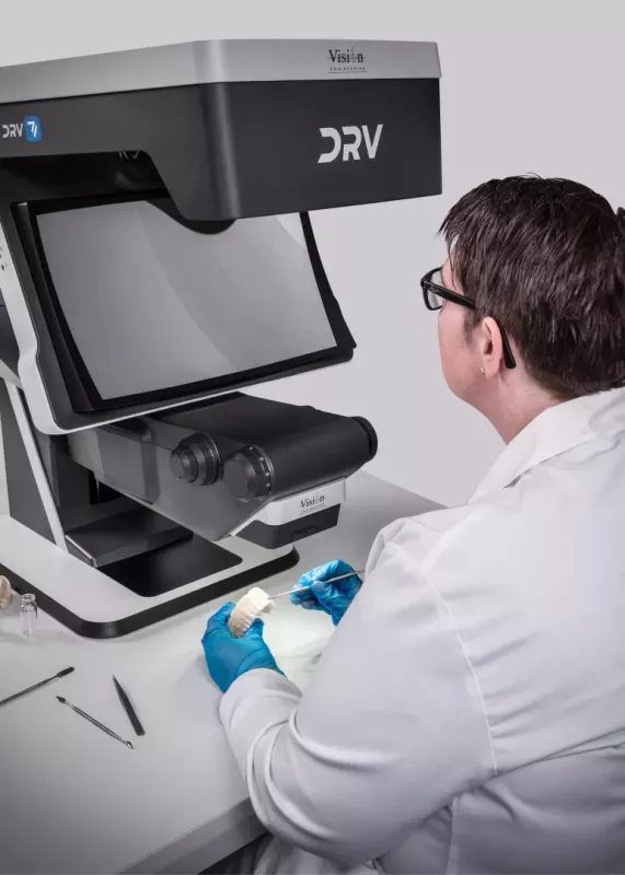 Ręce technika w&nbsp;rękawiczkach kontrolujące model zębowy pod mikroskopem 3D FHD DRV-Z1 w&nbsp;laboratorium stomatologicznym