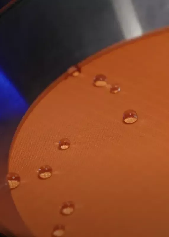 Krople wody na powierzchni tkaniny podczas badania wodoodporności w&nbsp;urządzeniu HydroView