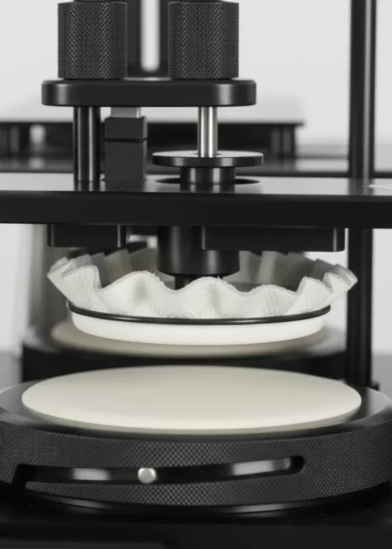 Zbliżenie próbki materiału i&nbsp;głowicy testowej w&nbsp;aparacie Martindale Motion