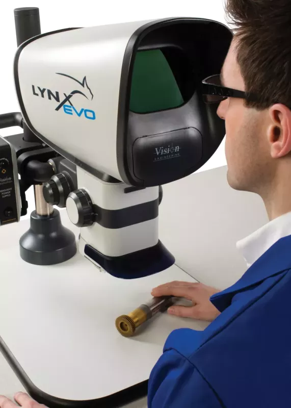 Widok od tyłu na użytkownika obsługującego mikroskop Lynx EVO na stole wieloosiowym