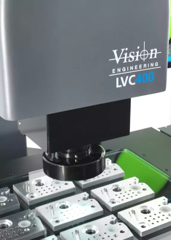 Optyczny system pomiarowy LVC 400 podczas pomiaru wielu małych metalowych detali na stole pomiarowym