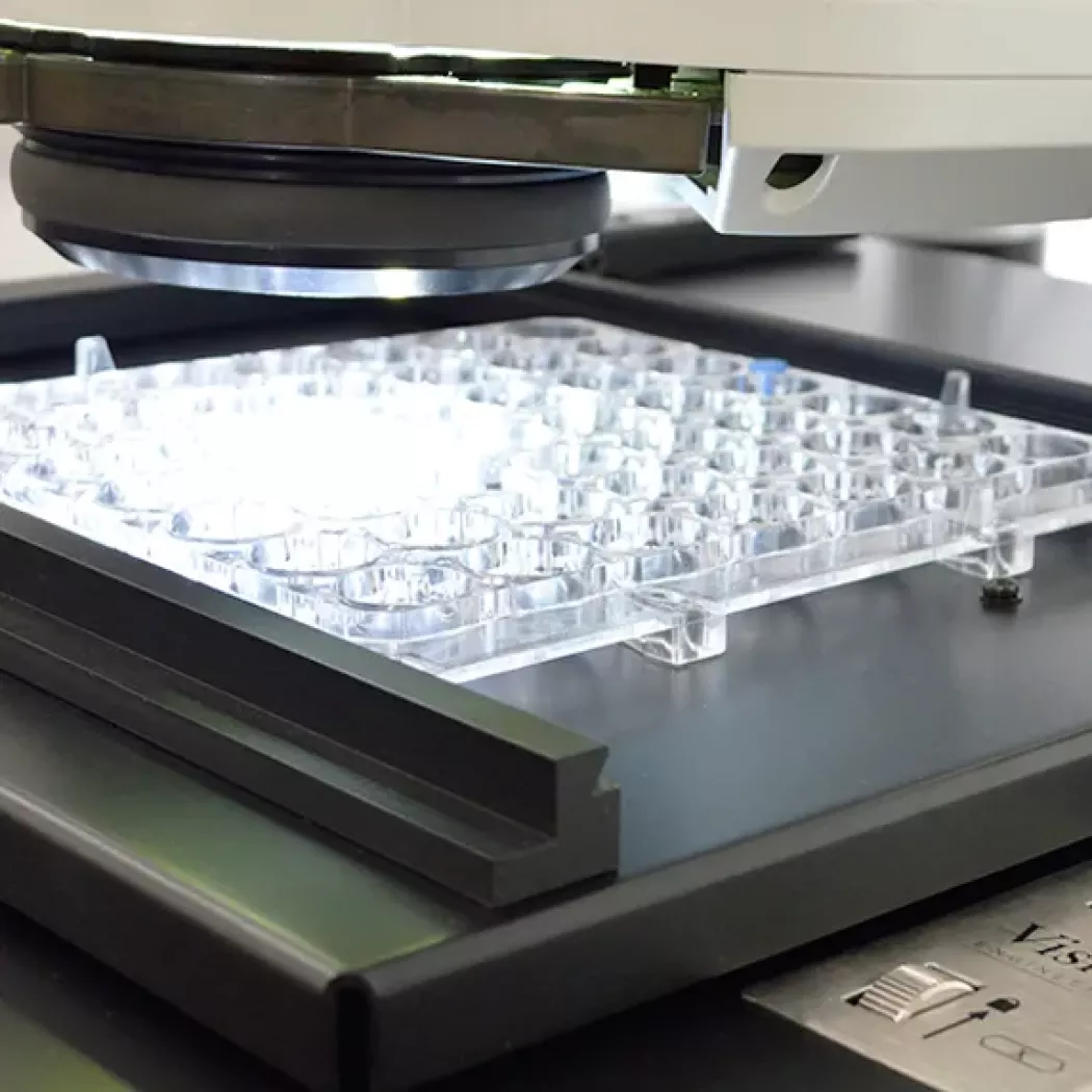 Zbliżenie na oświetlenie mikroskopu Evotis Lynx EVO podczas kontroli przezroczystego elementu