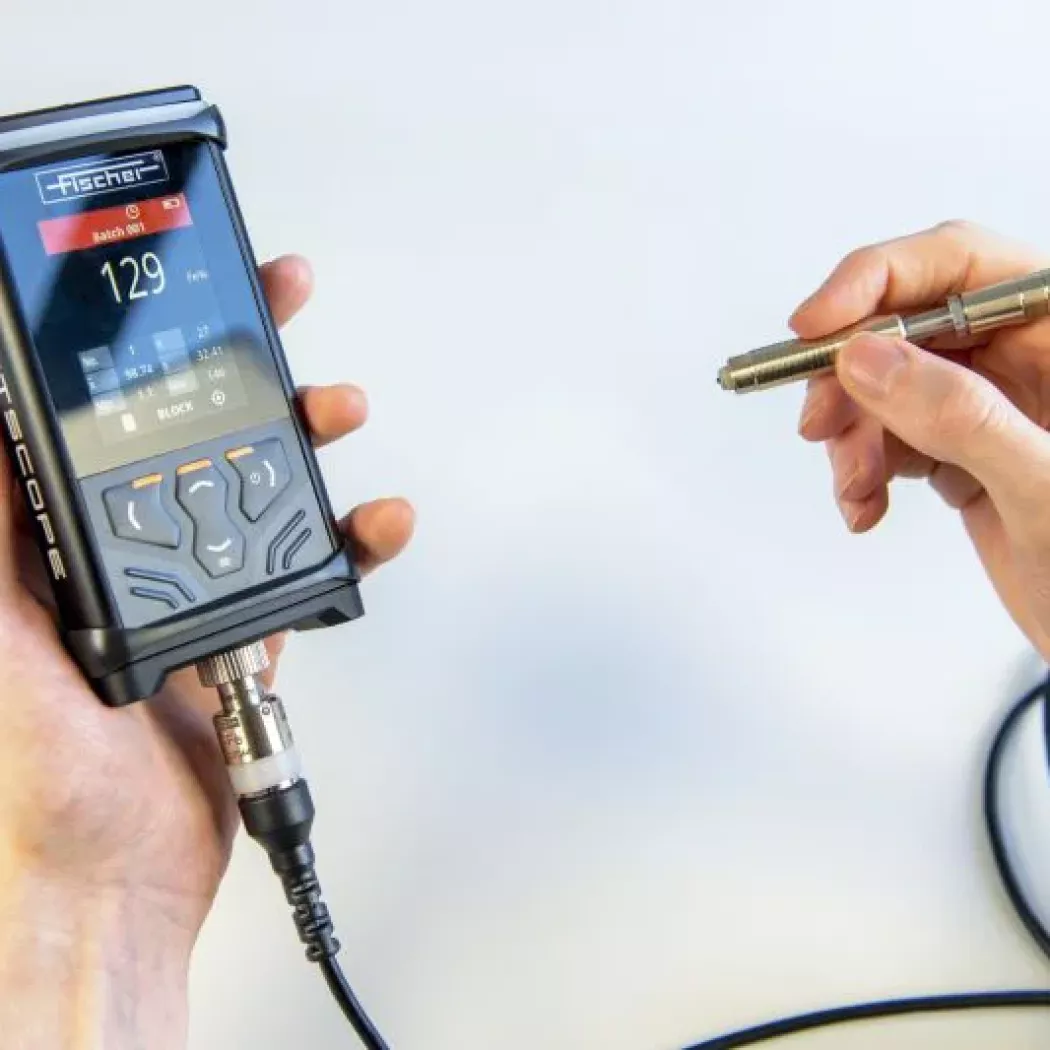 FERITSCOPE DMP30 w&nbsp;dłoni z&nbsp;podłączoną sondą pomiarową