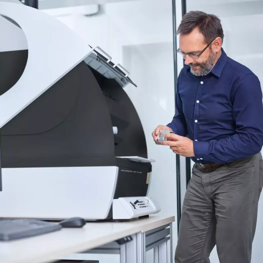 Operator przy stanowisku pomiarowym FISCHERSCOPE X-RAY XDV-μ podczas analizy próbki