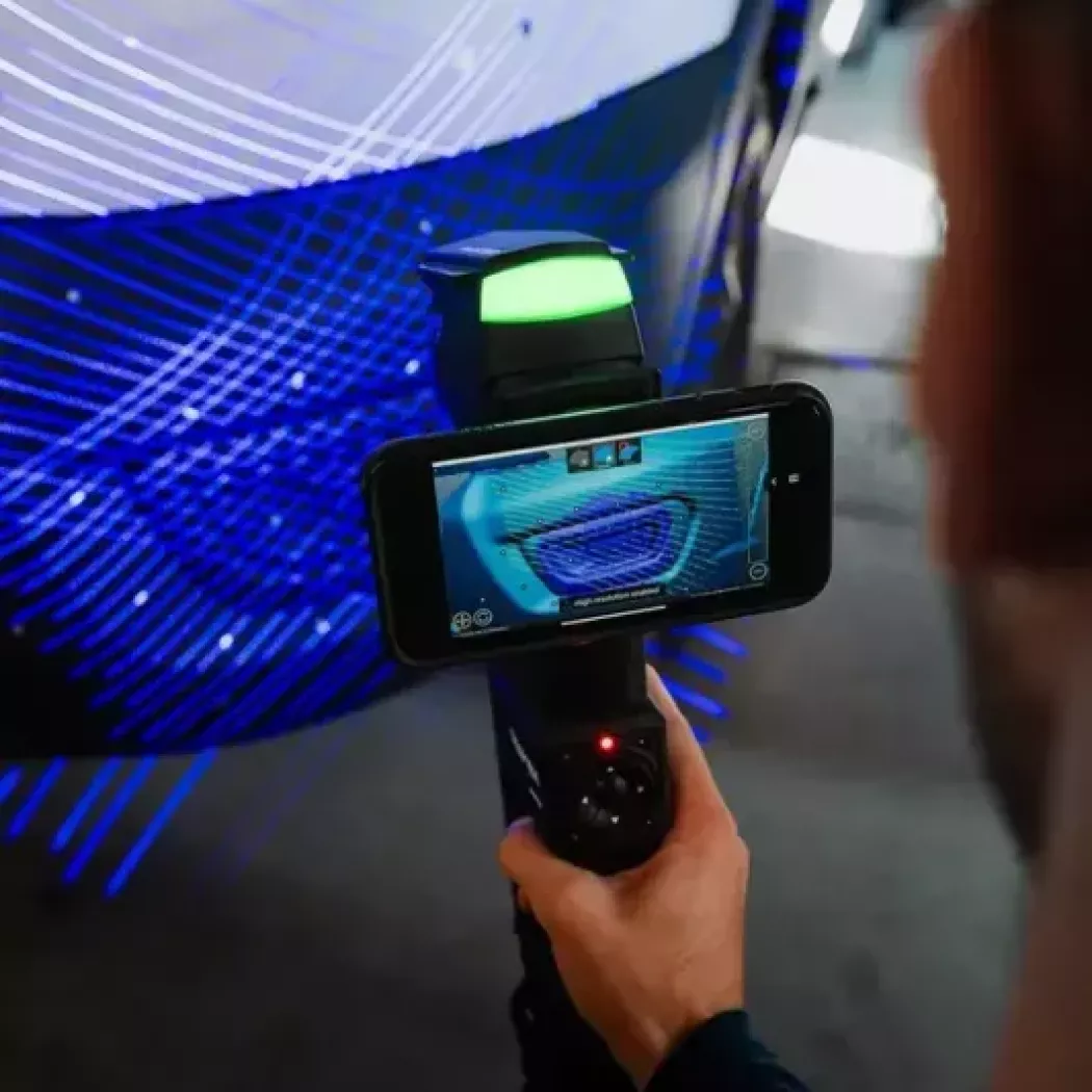 Creaform HandySCAN 3D MAX skanuje zderzak samochodu; podgląd skanu w&nbsp;czasie rzeczywistym na urządzeniu mobilnym