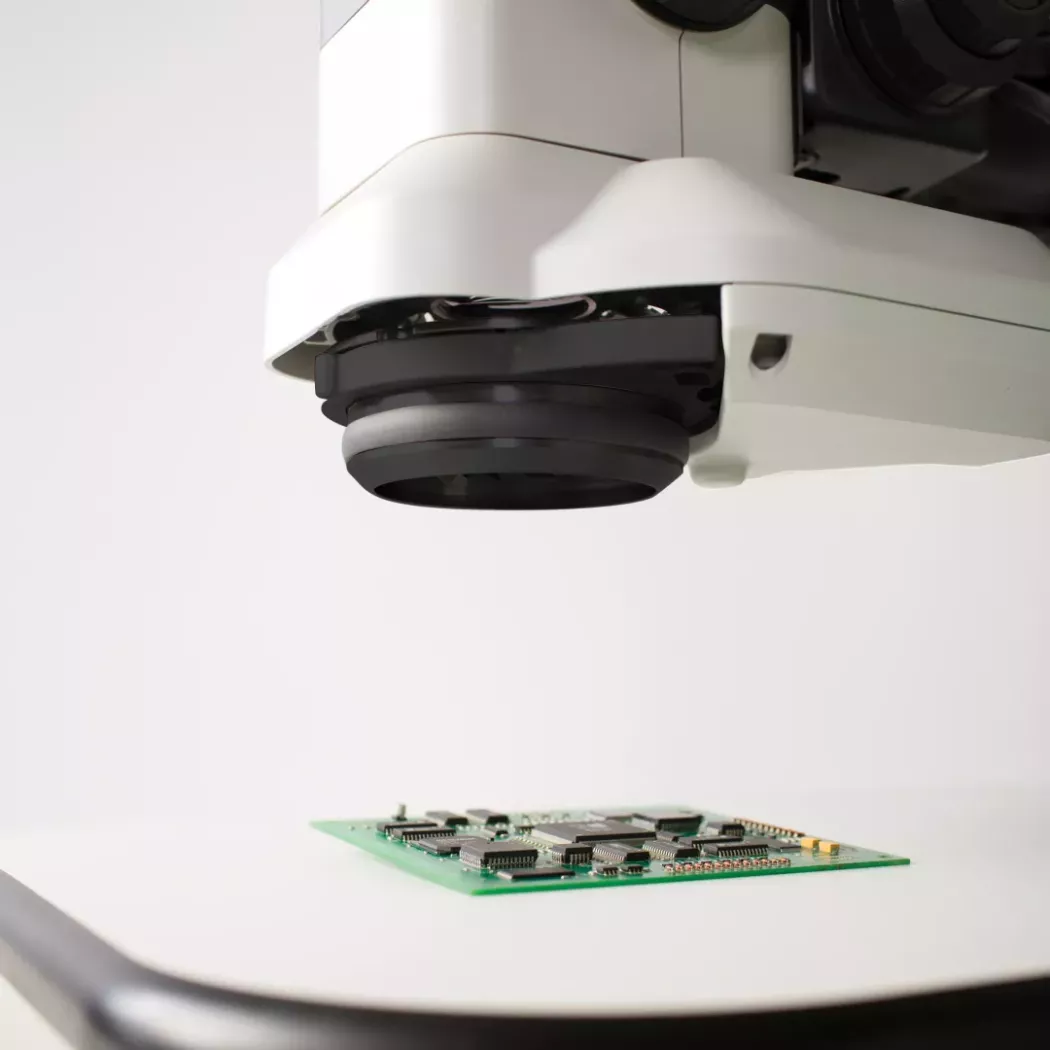 Głowica mikroskopu inspekcyjnego Lynx EVO nad płytką PCB podczas kontroli jakości
