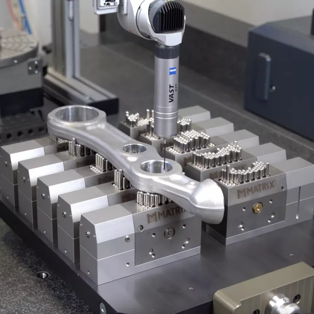 Odlew aluminiowy zamocowany na kilku modułach MATRIX; sonda CMM wykonuje pomiar otworu z&nbsp;wysoką powtarzalnością.