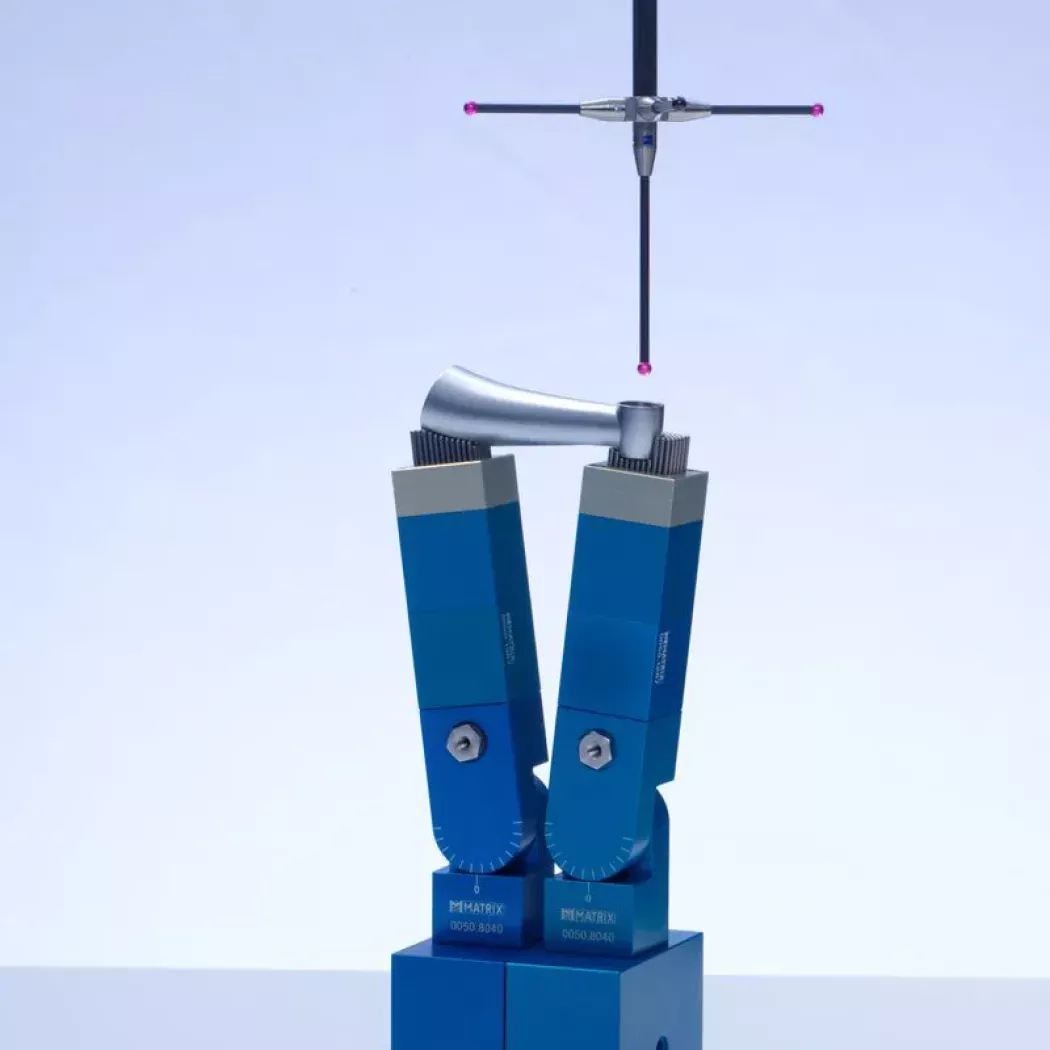 Zestaw uchwytów MATRIX z&nbsp;pinami na maszynie współrzędnościowej; sonda CMM nad precyzyjnie ustalonym detalem.