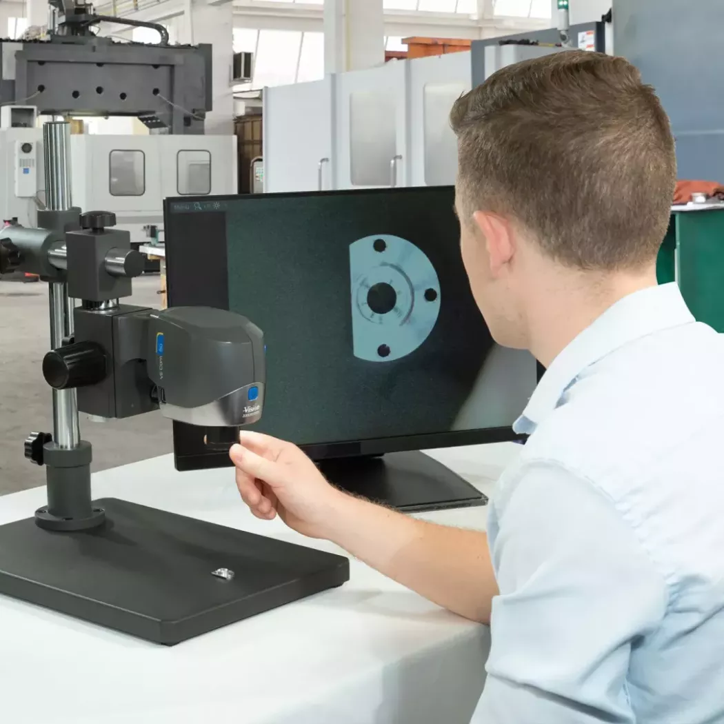 Operator wykorzystuje mikroskop cyfrowy VE Cam na wysięgniku do inspekcji detalu w&nbsp;przemyśle