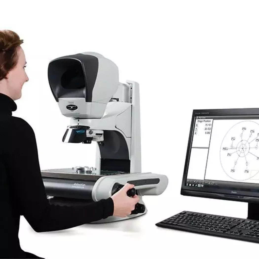 Operator obsługuje mikroskop pomiarowy Hawk przy stanowisku z&nbsp;monitorem pomiarowym
