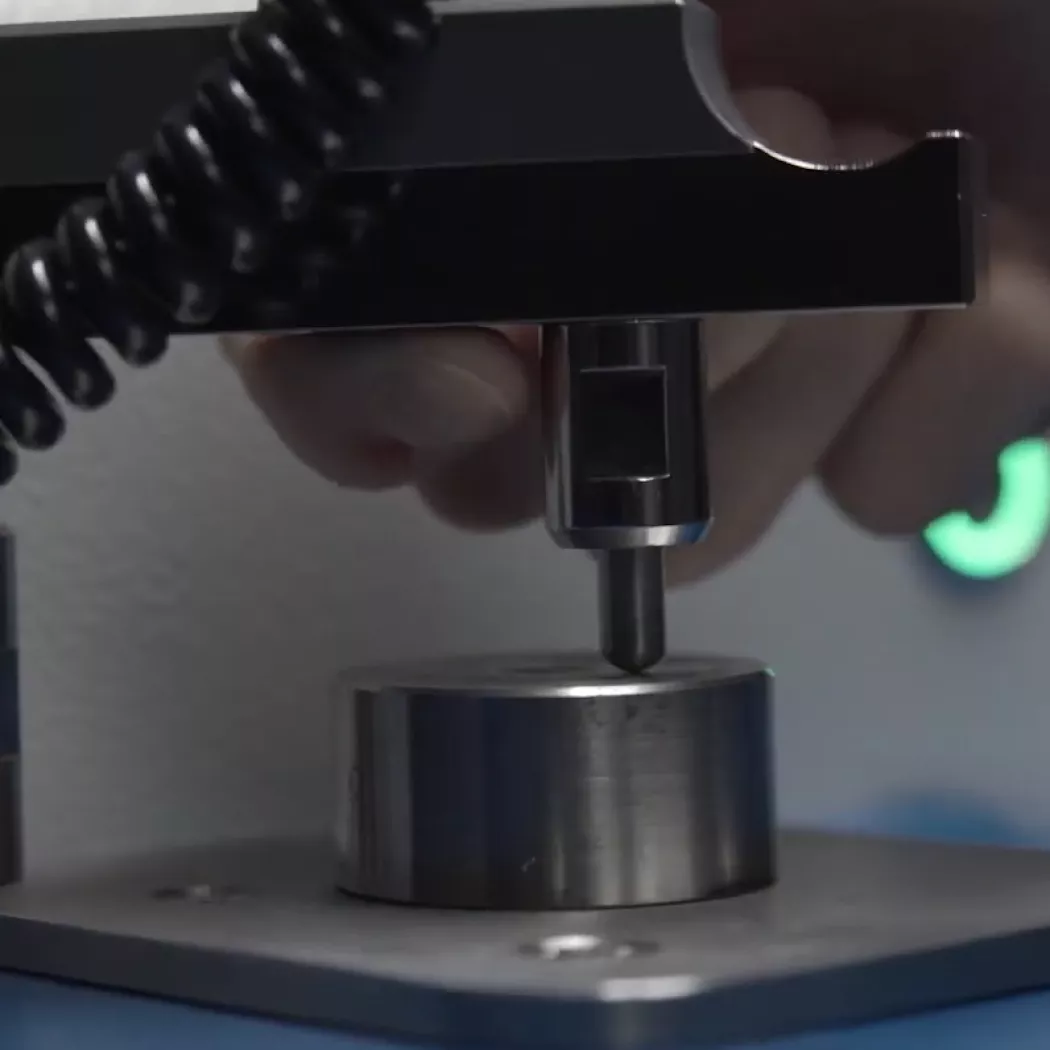 Ręczne umieszczanie próbki metalu w&nbsp;spektrometrze MiniLab 150