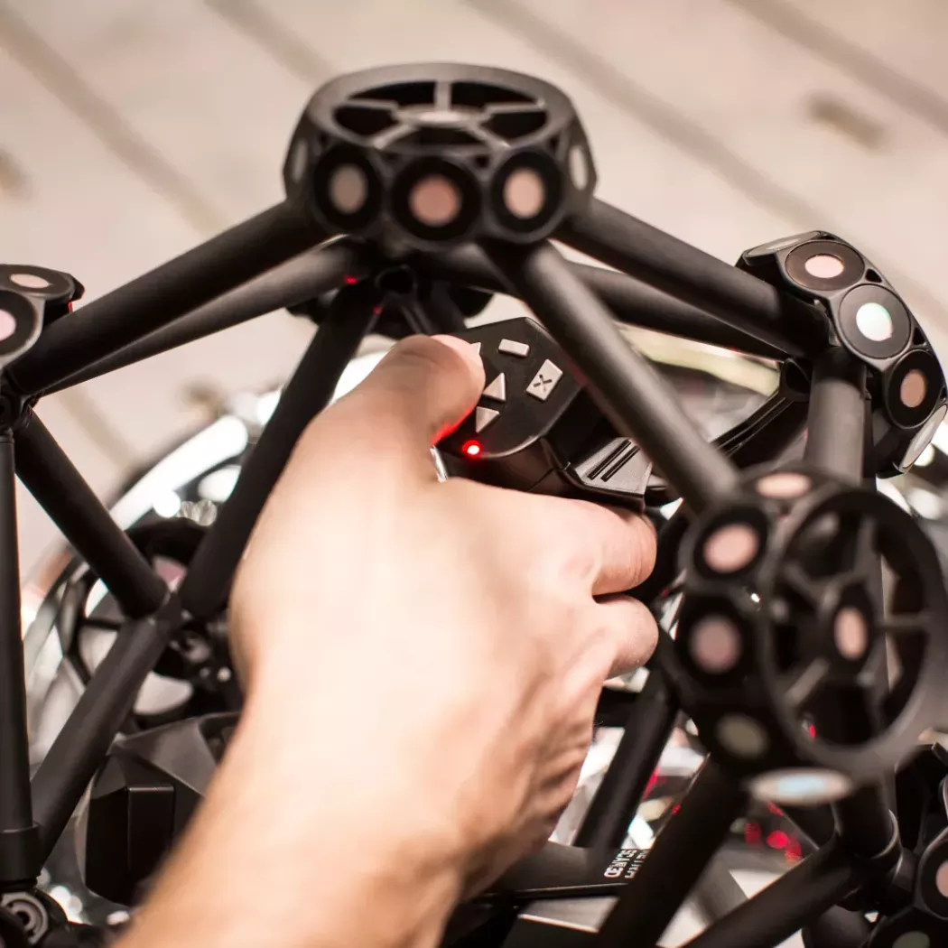 Zbliżenie na dłoń operatora obsługującego wielofunkcyjne przyciski ręcznego skanera 3D MetraSCAN BLACK podczas pomiaru